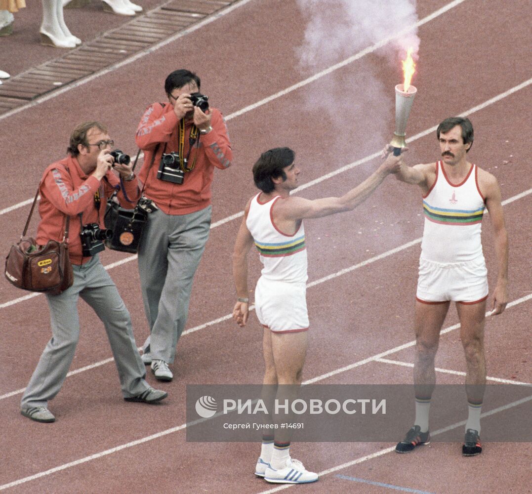 Сергей Белов принимает факел с олимпийским огнем