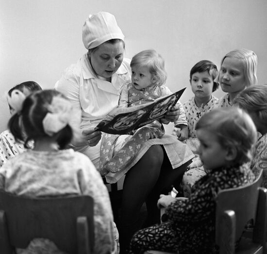 Медицинская сестра отделения детской хирургии читает сказку юным пациентам