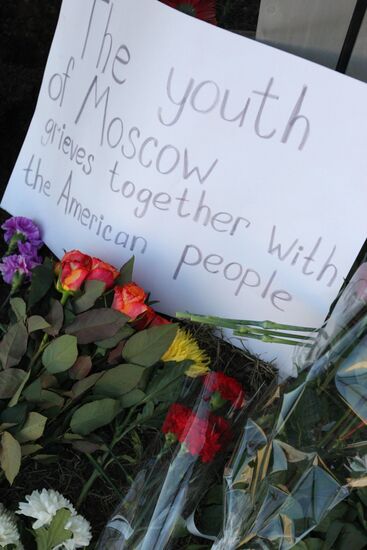 Москвичи несут цветы к зданию посольства США в Москве