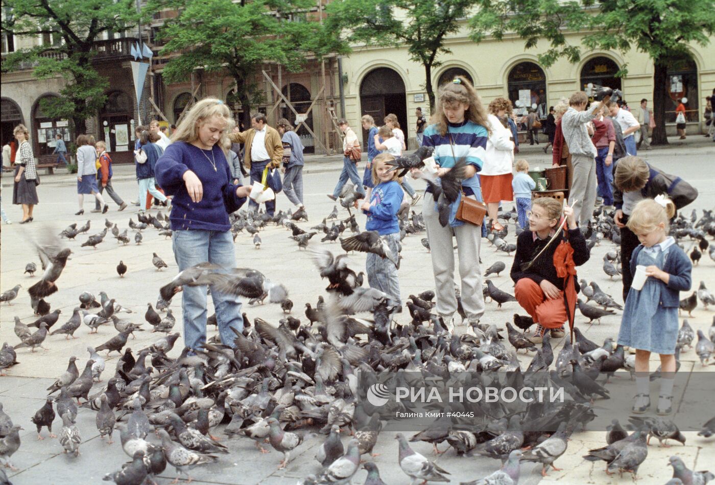 Дети кормят голубей на Рыночной площади в Кракове