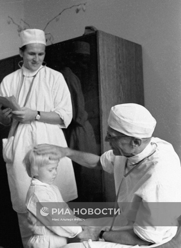 Хирург Николай Амосов во время осмотра маленькой пациентки