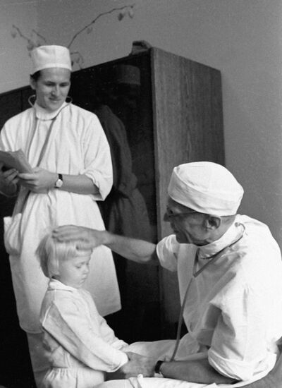 Хирург Николай Амосов во время осмотра маленькой пациентки