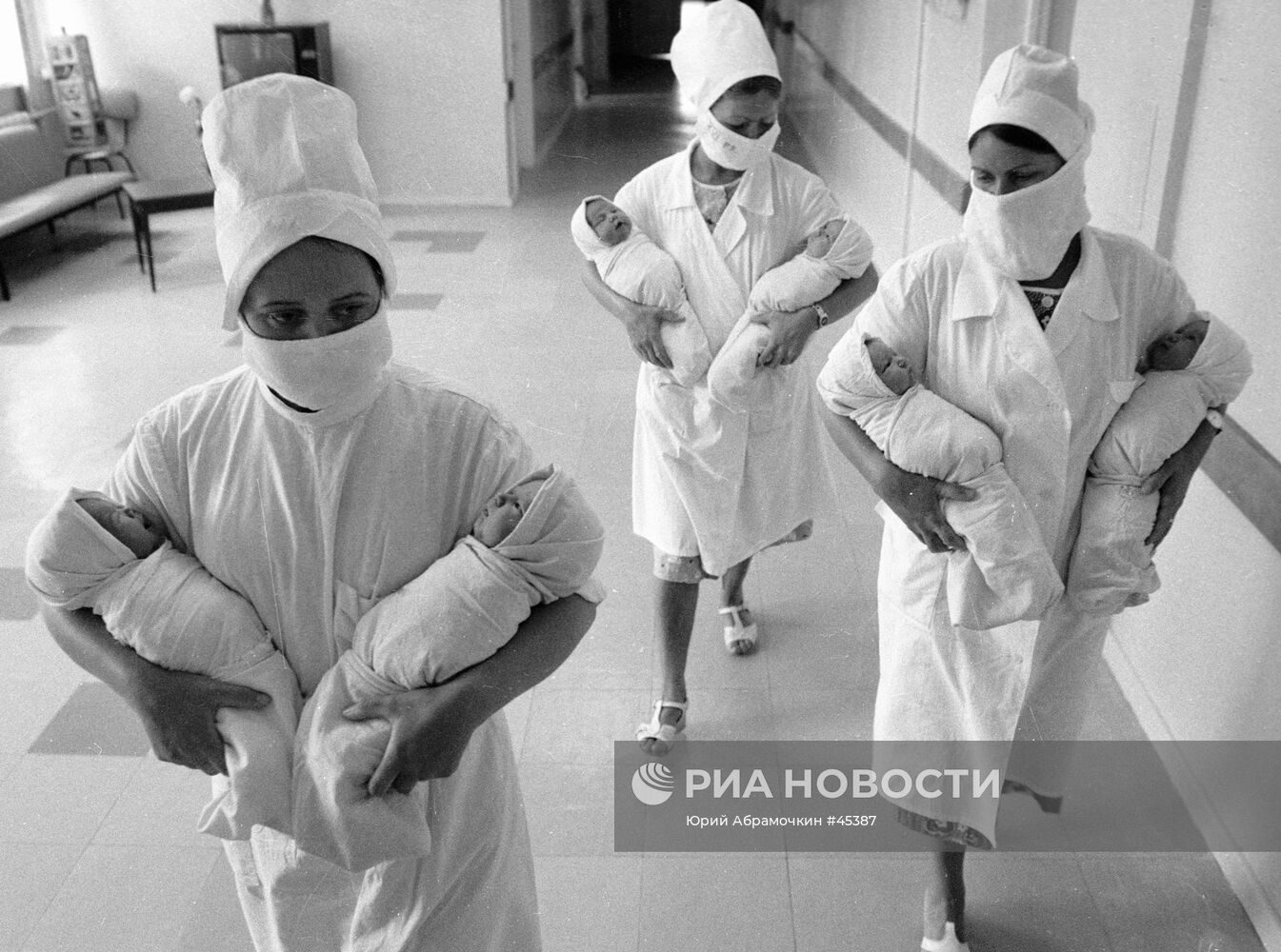 Медицинские сестры несут на руках новорожденных младенцев