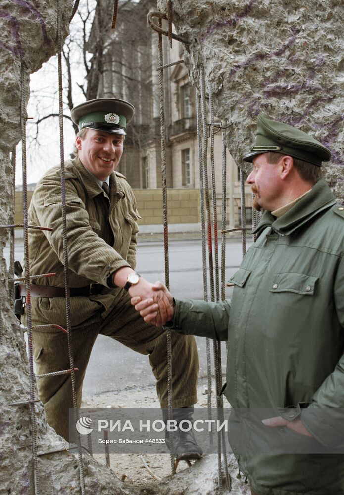 Пограничник из ГДР и полицейский из ФРГ обмениваются рукопожатие
