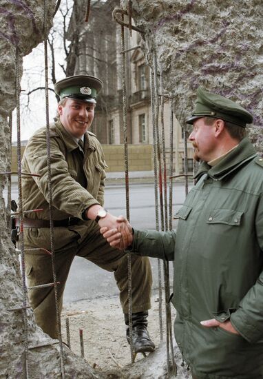 Пограничник из ГДР и полицейский из ФРГ обмениваются рукопожатие