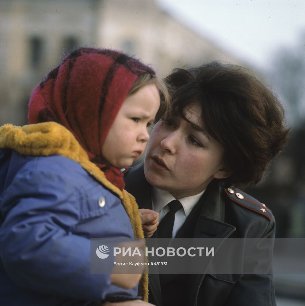 Инспектор детской комнаты милиции с ребенком