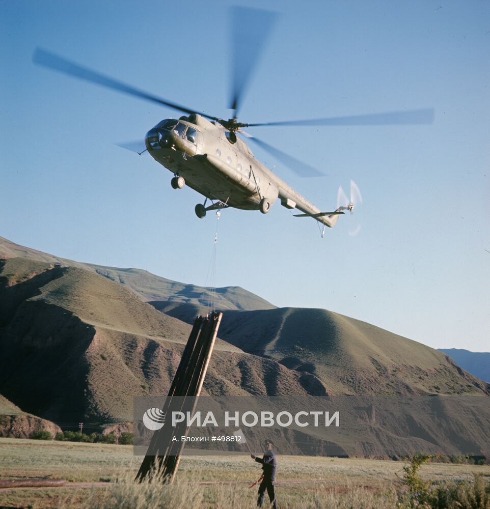 Вертолет МИ-8 перевозит связки опор