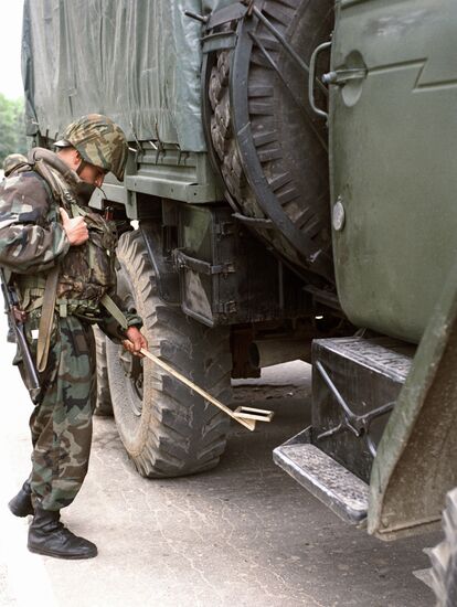 Боец проверяет автомашину на КПП