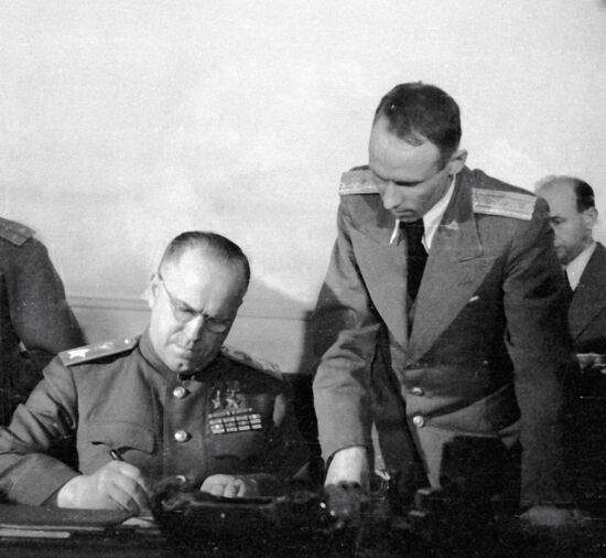 Георгий Константинович Жуков (слева) подписывает Акт о безоговорочной капитуляции фашистской Германии