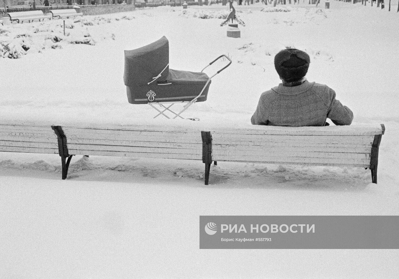 Дедушка зимой с коляской в сквере на площади Пушкина