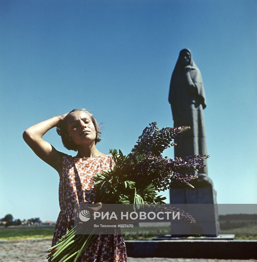 Девушка с цветами около памятника
