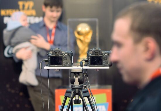 Любители футбола фотографируюся с Кубком мира ФИФА