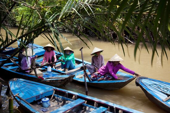 Крестьяне на лодках в устье реки Меконг