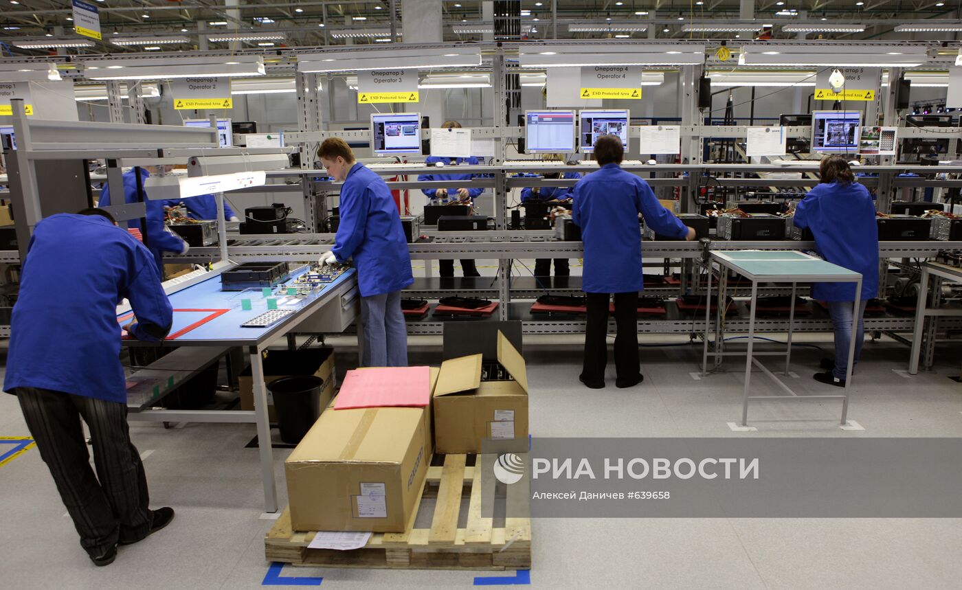 Рабочие в цехе завода по производству персональных компьютеров