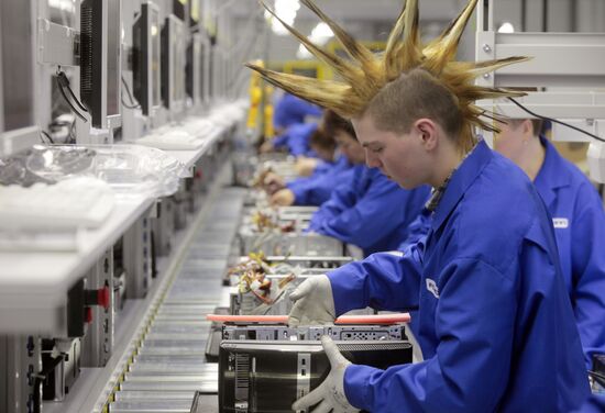 Рабочие в цехе завода по производству персональных компьютеров