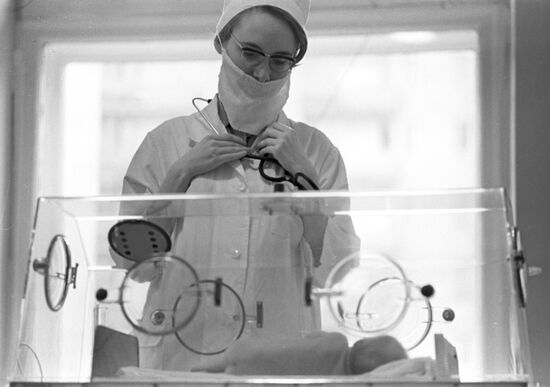 Врач осматривает новорожденного