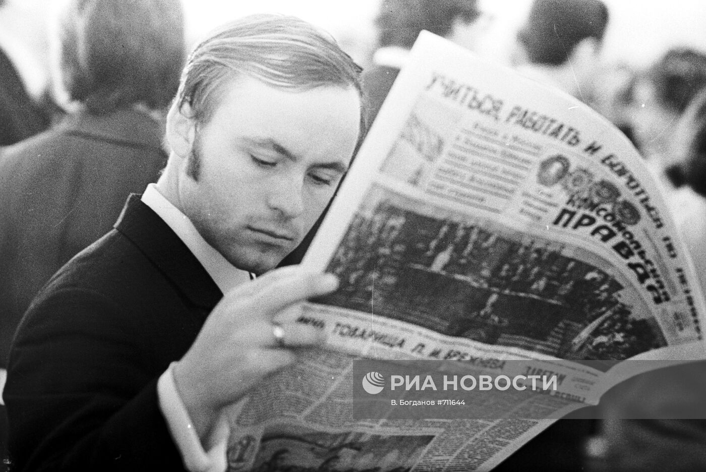 Молодой человек читает газету