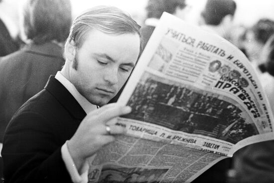 Молодой человек читает газету