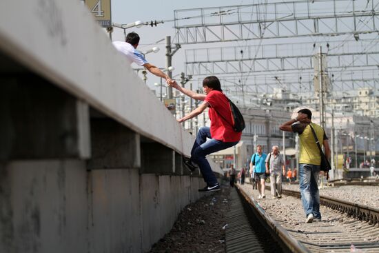 Пассажиры на железнодорожных путях Курского вокзала