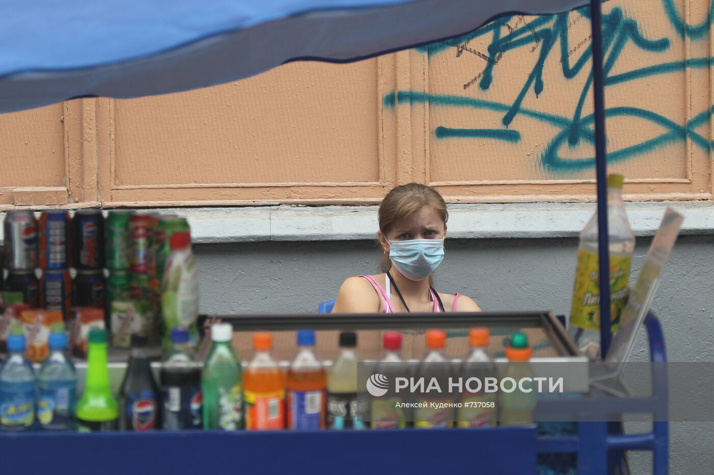 Продавщица прохладительных напитков в защитной маске