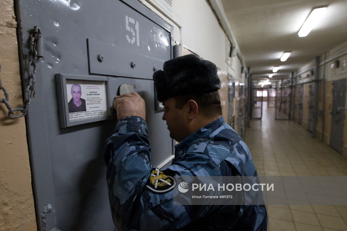 Сотрудник охраны ИК-1 смотрит в глазок одной из камер