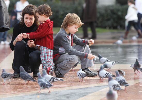 Дети кормят голубей на площади Каталонии