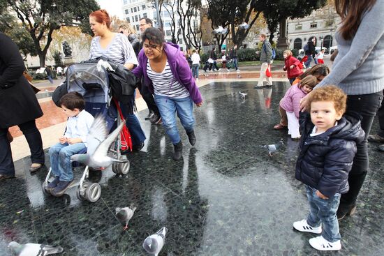 Дети кормят голубей на площади Каталонии