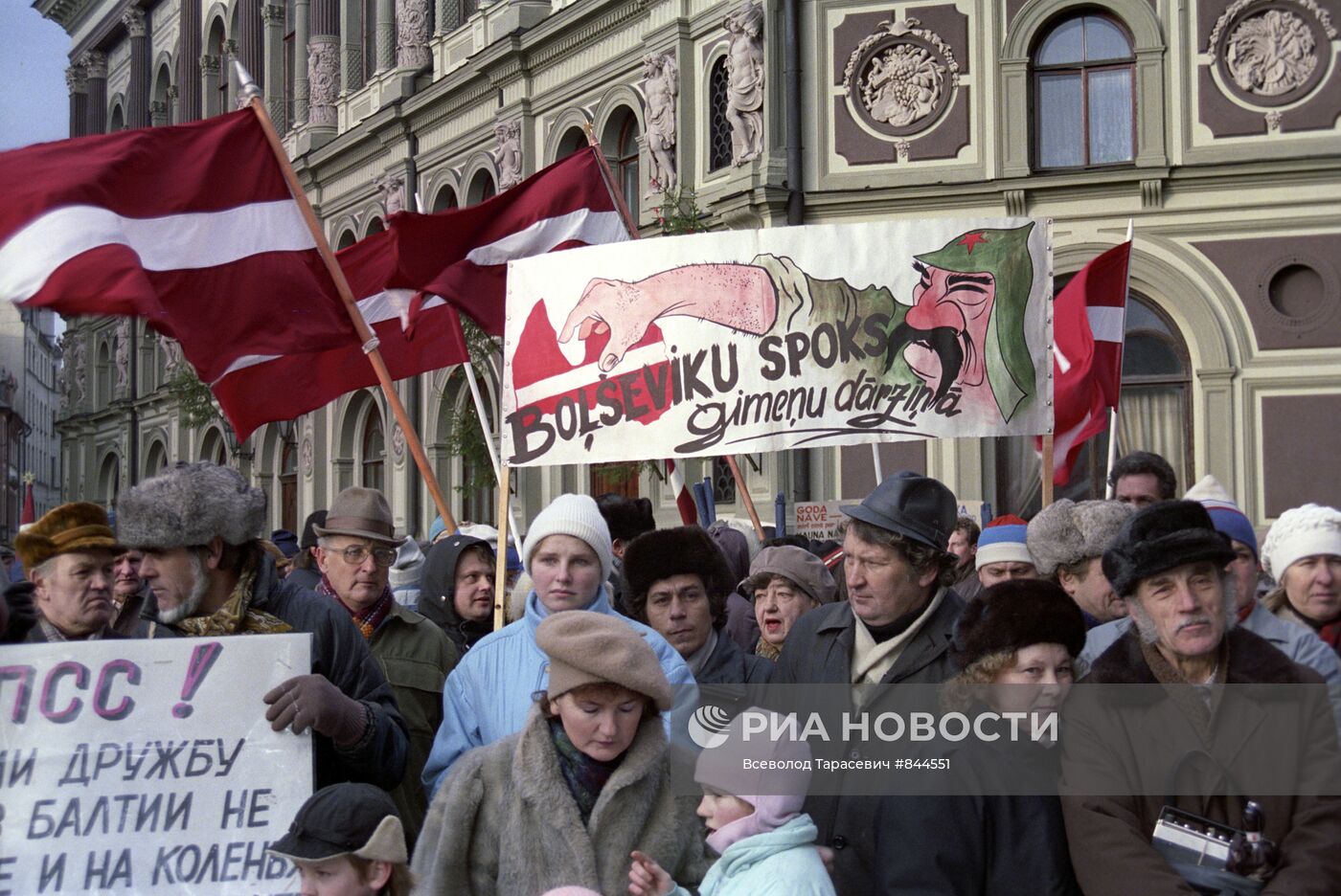 Колонна демонстрантов у здания парламента Латвии