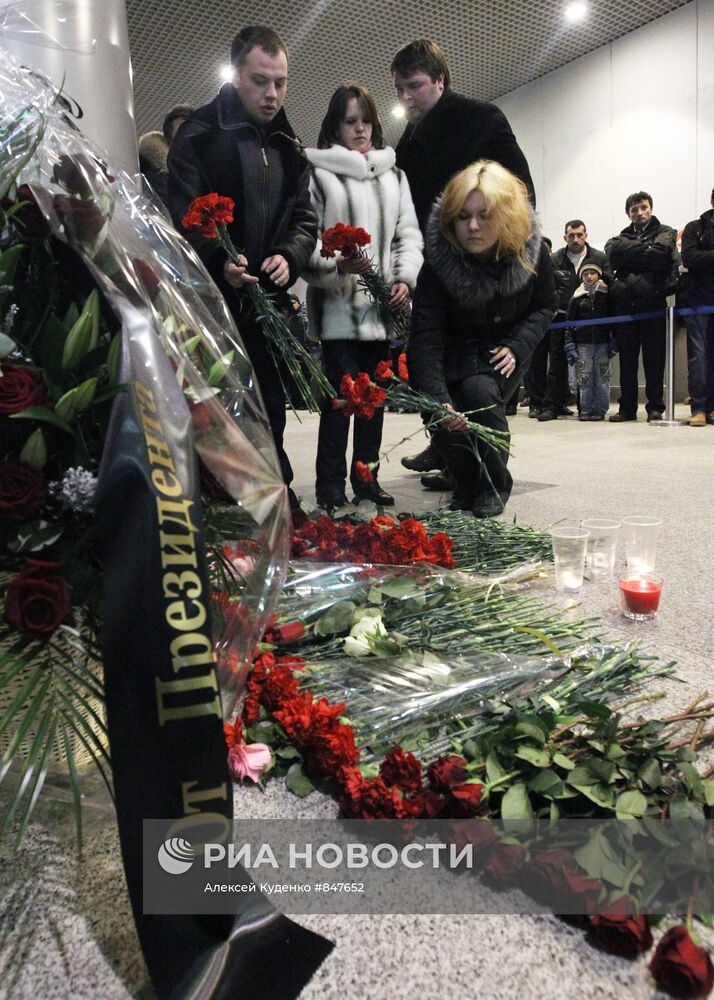 Цветы и поминальные свечи рядом с местом теракта в "Домодедово"