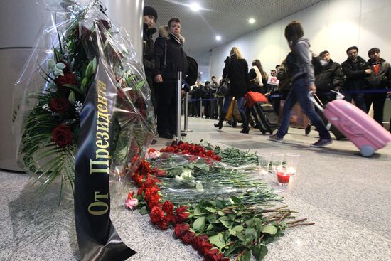 Цветы и поминальные свечи рядом с местом теракта в "Домодедово"