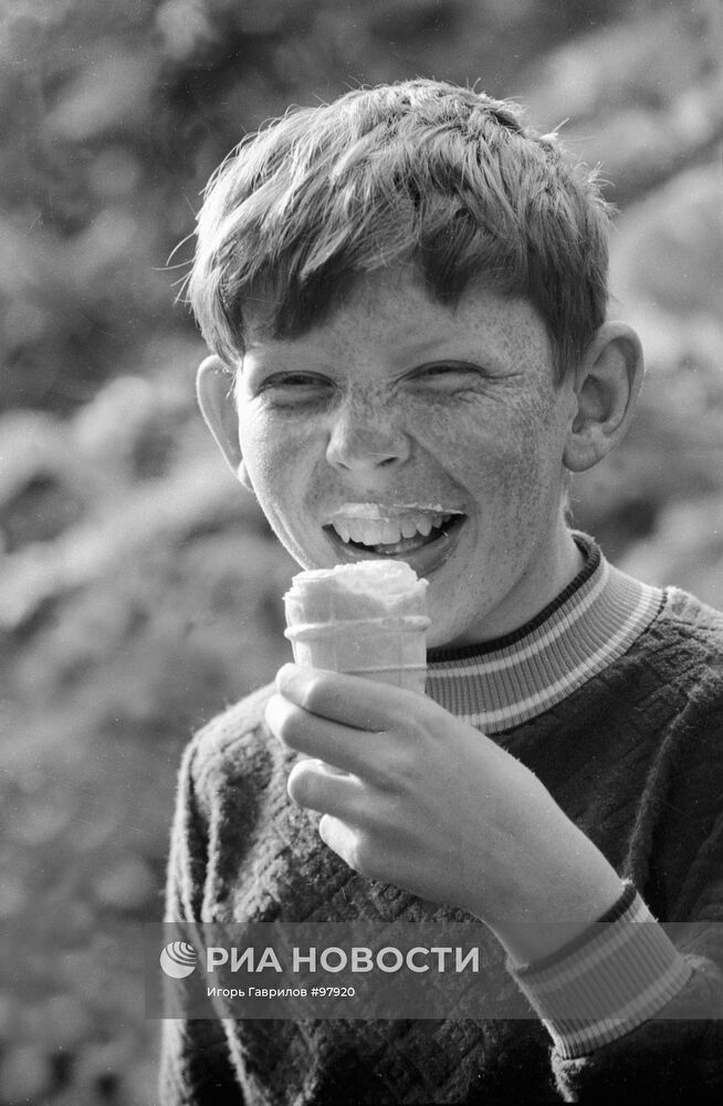Мальчик ест мороженое