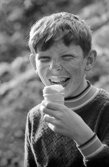 Мальчик ест мороженое