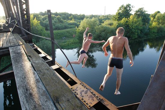 Мальчишки прыгают со стального железнодорожного моста