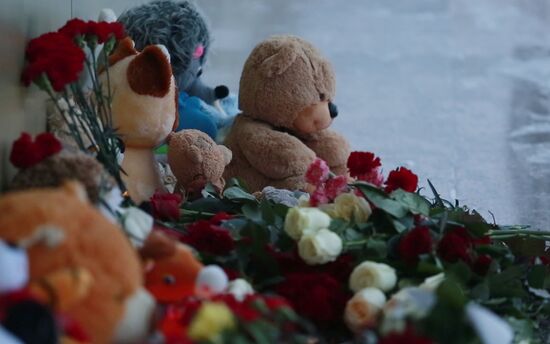 Жители Нефтеюганска несут цветы к спортивному центру, где занимались погибшие в ДТП дети