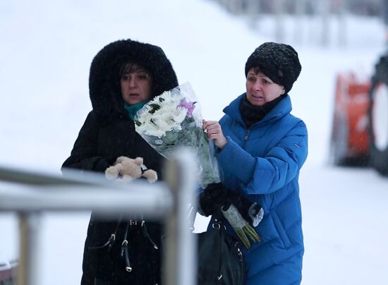 Жители Нефтеюганска несут цветы к спортивному центру, где занимались погибшие в ДТП дети
