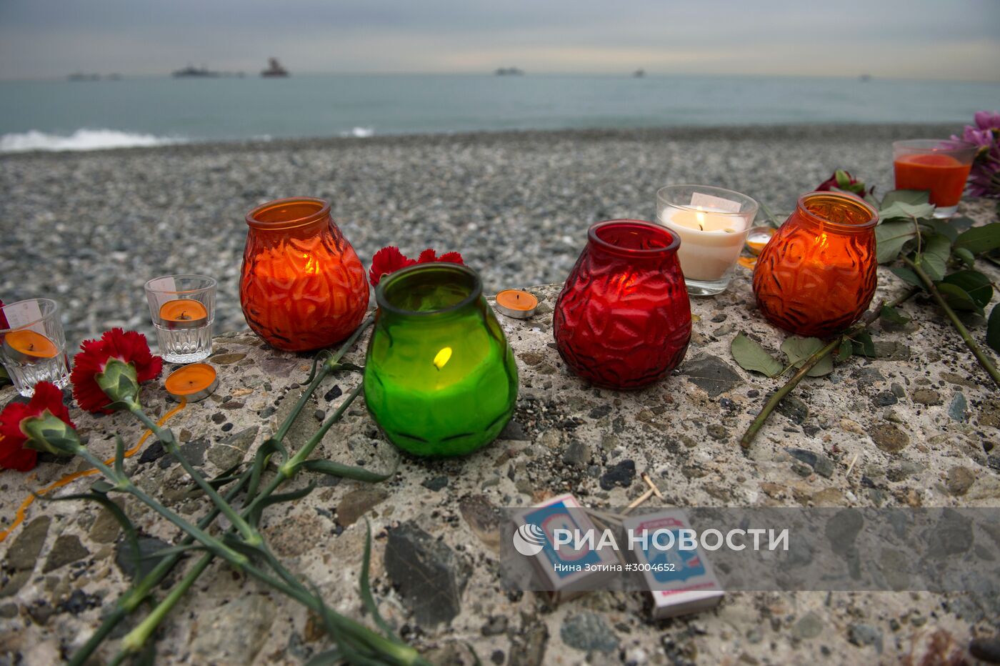 В Сочи жители города несут цветы и свечи к площади Южного мола морского порта