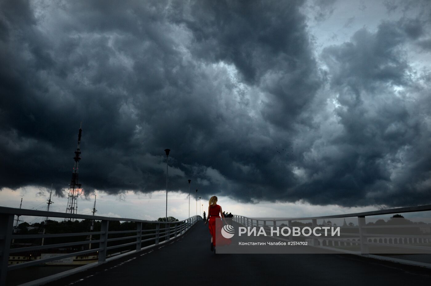Девушка бежит по пешеходному мосту в Великом Новгороде.