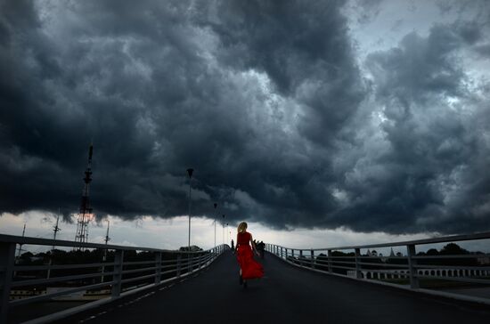 Девушка бежит по пешеходному мосту в Великом Новгороде.