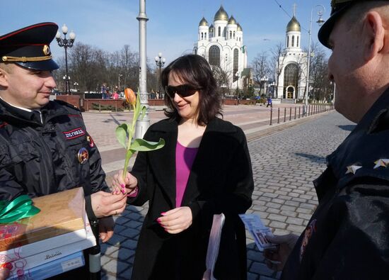 Сотрудники ГИБДД вручают цветы женщинам-водителям