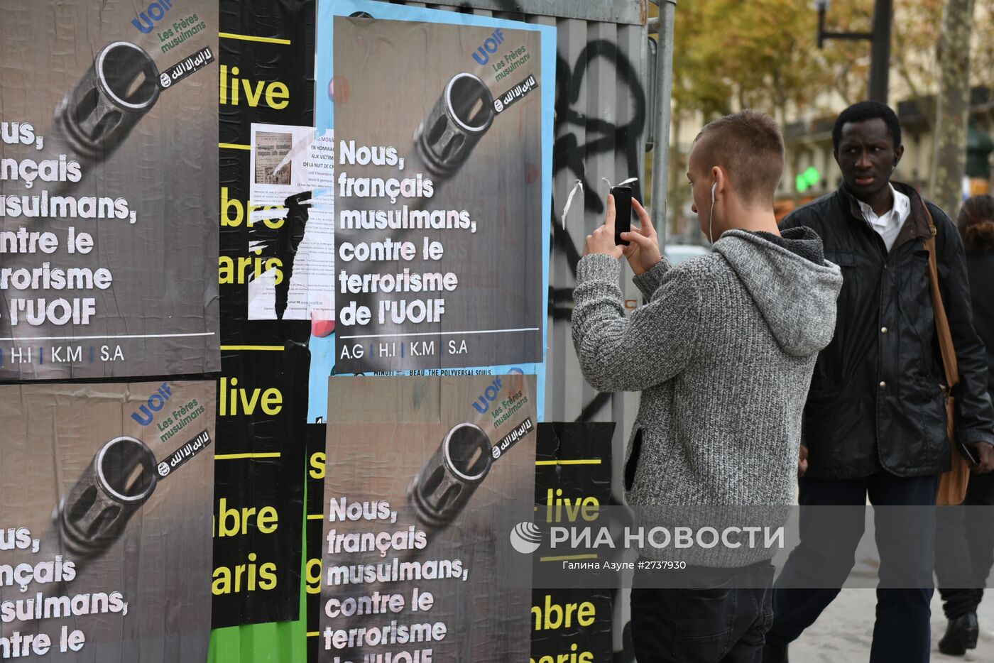 Парижанин снимает плакат с надписью "Мы французские мусульмане против терроризма Союза Исламских Организаций Франции" на улице Вольтер недалеко от театра "Батаклан", где произошел один из серии терактов. Место: Франция, Париж. Автор: Галина Азуле/РИА Новости. Ситуация в Париже после серии терактов