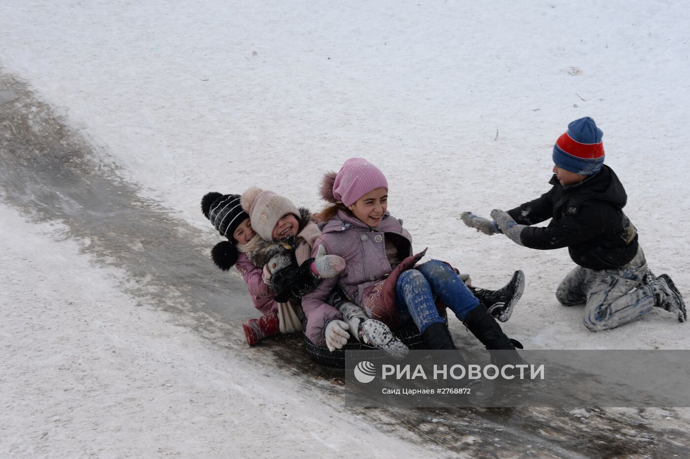 Дети катаются на ледяной горке в Грозном