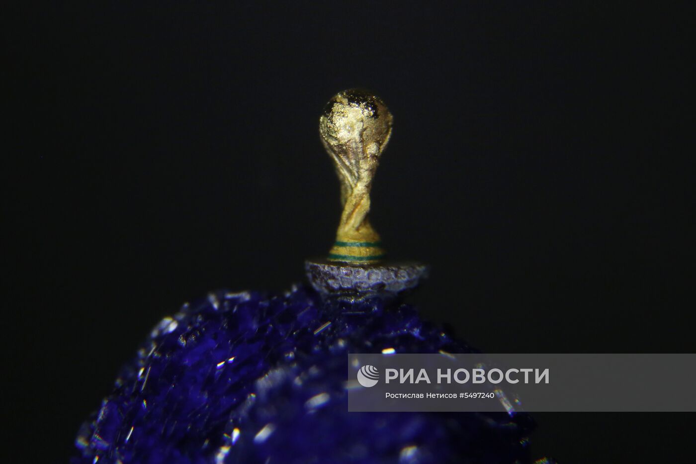 Новосибирский мастер изготовил копию кубка ЧМ по футболу на срезе макового зернышка