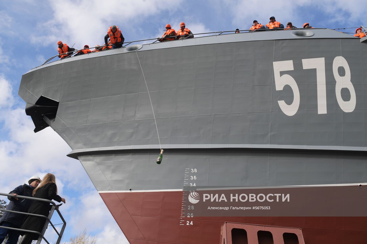 Рабочий Ленинградского судостроительного завода "Пелла" разбивает бутылку о борт малого ракетного корабля "Буря" проекта 22800 на церемонии спуска на воду. Место: Россия, Ленинградская область. Автор: Александр Гальперин/РИА Новости. Спуск на воду малого ракетного корабля "Буря"