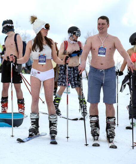 Массовый спуск сноубордистов и лыжников в купальниках