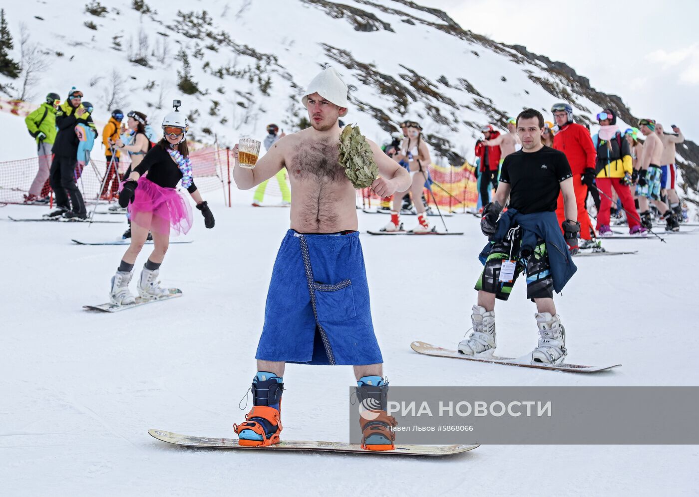 Массовый спуск сноубордистов и лыжников в купальниках