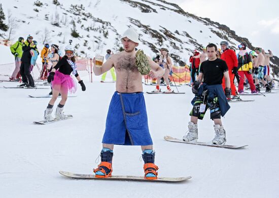 Массовый спуск сноубордистов и лыжников в купальниках