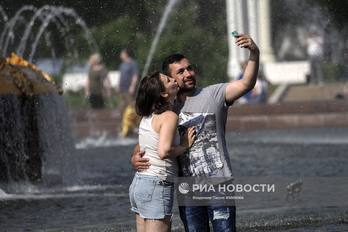 Молодые люди отдыхают у фонтана на ВДНХ в Москве