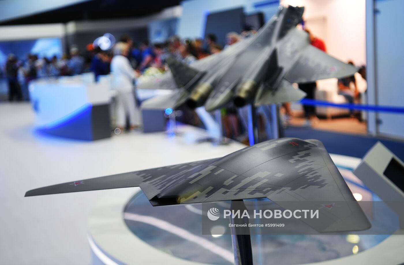 Макеты беспилотного летательного аппарата С-70 "Охотник" (на первом плане) и многофункционального истребителя Су-57 на Международном авиационно-космическом салоне МАКС-2019 в подмосковном Жуковском. Место: Россия, Московская область, Жуковский. Автор: Евгений Биятов/РИА Новости. Международный авиационно-космический салон МАКС-2019. День четвертый