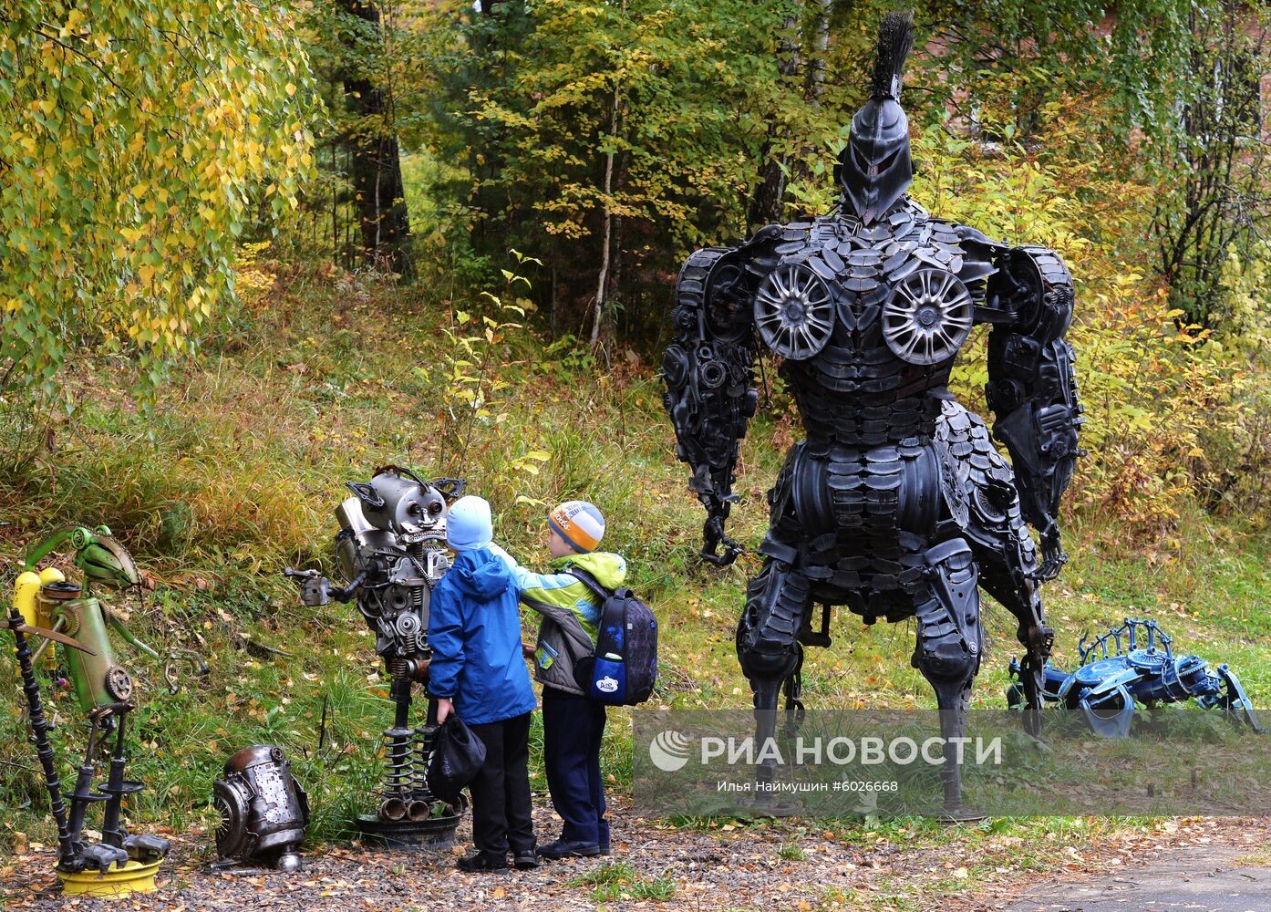 Школьники осматривают экспонаты выставки металлических скульптур из автомобильных запчастей автослесаря Сергея Кулагина на территории школы № 9 в Дивногорске. Место: Россия, Красноярский край, Дивногорск. Автор: Илья Наймушин/РИА Новости. Выставка металлических скульптур из автомобильных запчастей в Дивногорске