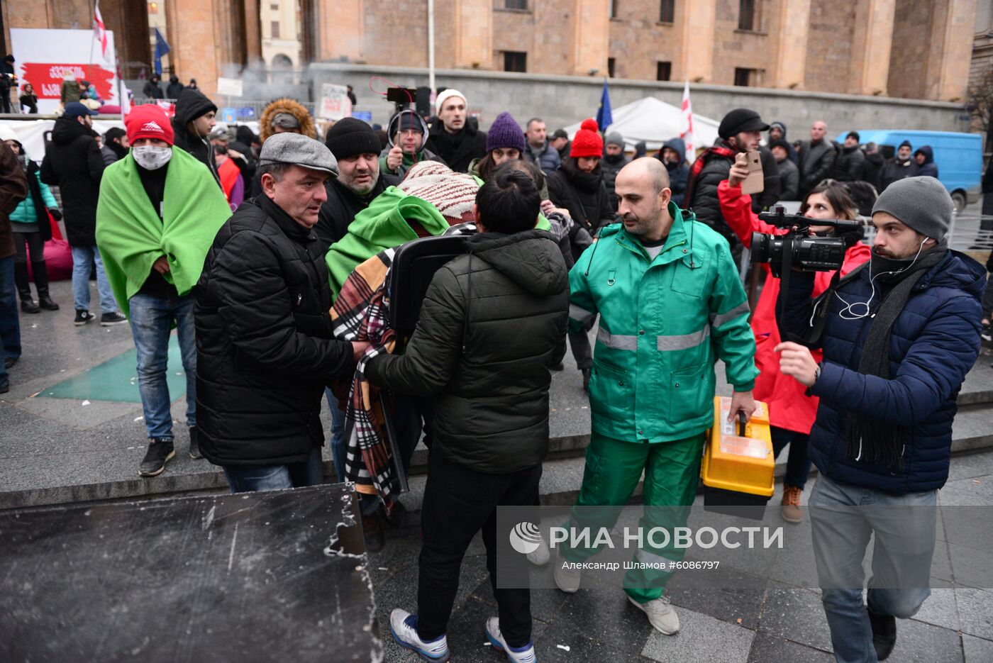 Одного из участников акции протеста перед зданием парламента в Тбилиси несут к машине скорой помощи. Акции протеста в Тбилиси начались после того, как парламент Грузии не принял поправки в конституцию по изменению избирательной системы. Отклоненные поправки предполагали проведение парламентских выборов в 2020 году по пропорциональной системе (вместо смешанной) и при нулевом избирательном барьере. Место: Грузия, Тбилиси. Автор: Александр Шламов/Sputnik/РИА Новости. Акция протеста в Тбилиси